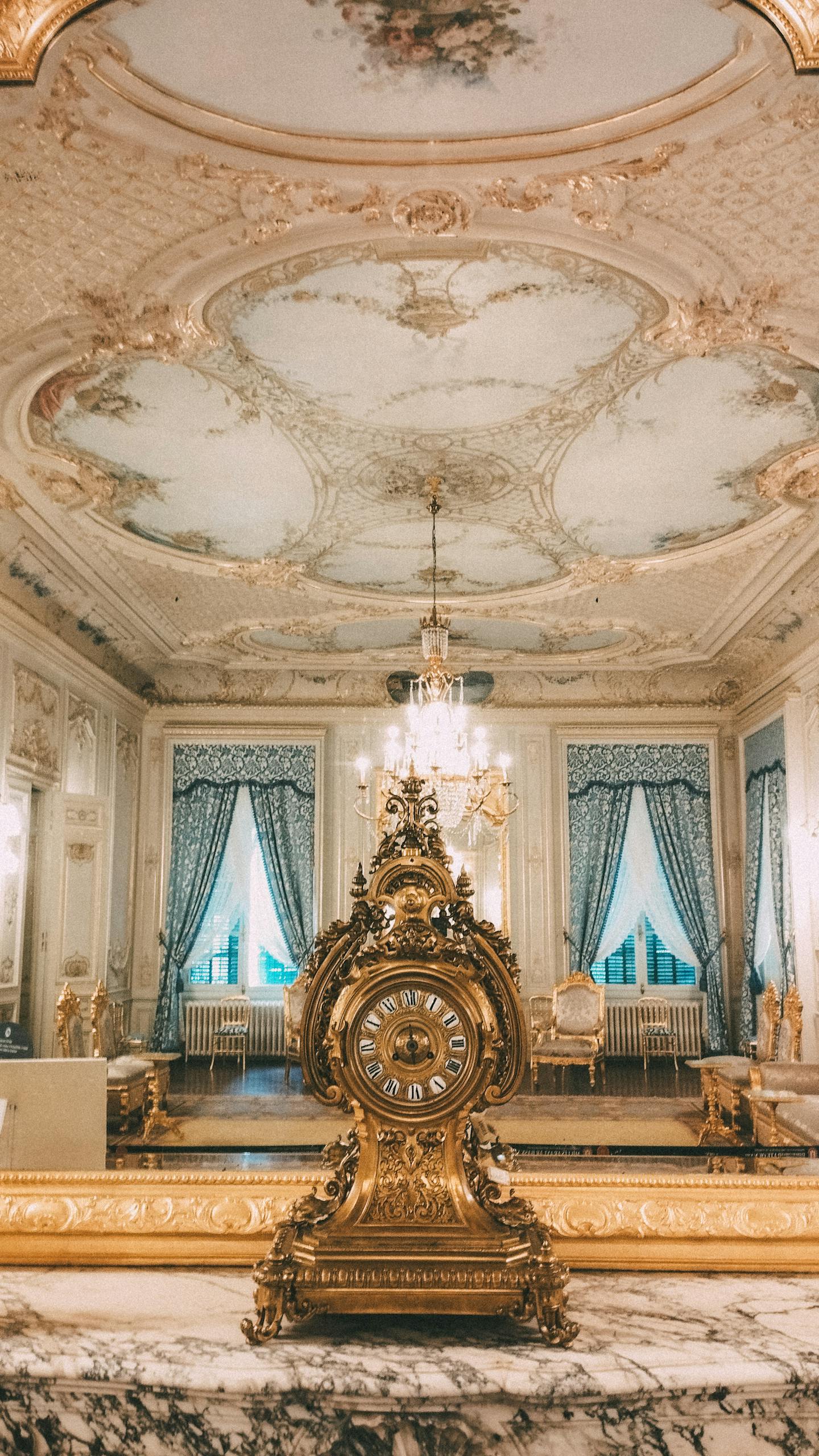 Magnificent baroque room with intricate ceiling and ornate clock in a palace in İstanbul.