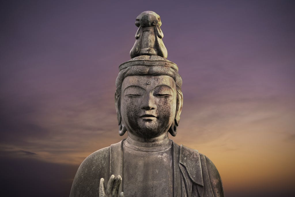 Serene close-up of a Buddha statue against a vibrant sunset sky in Tokyo, Japan.